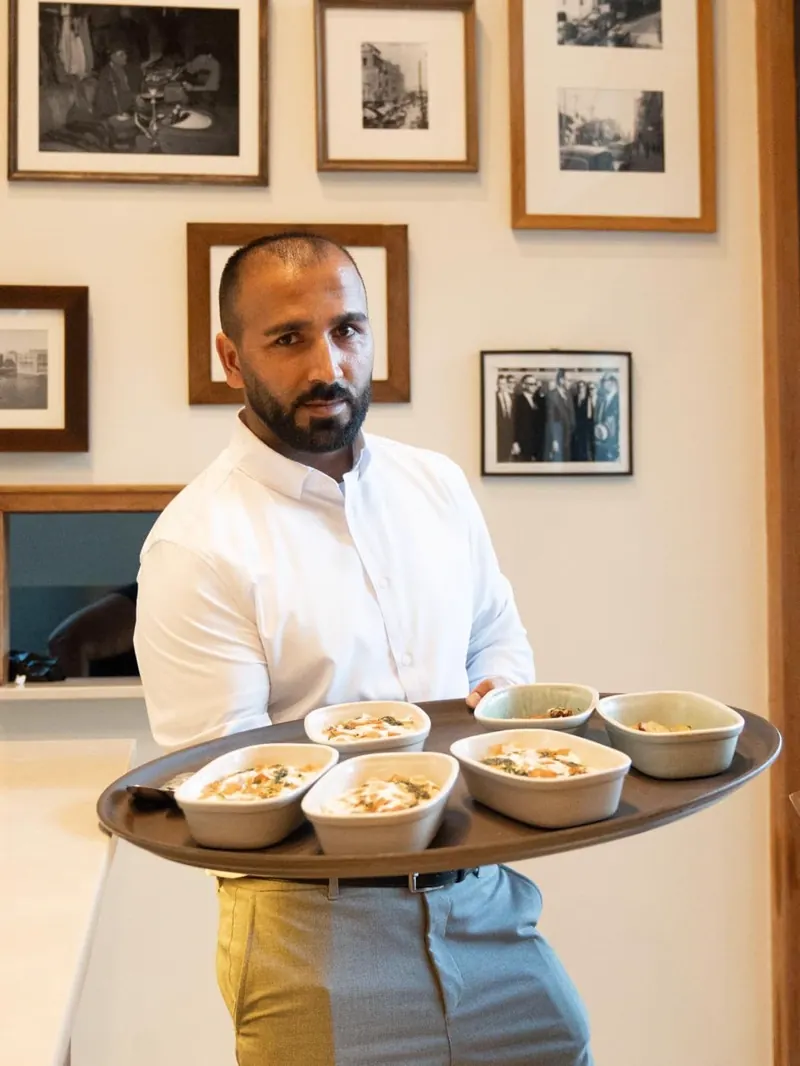 Camarero presentando una mesa abundante de mezze en du Liban, La Moraleja