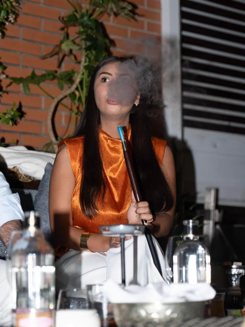 Cliente fumando shisha en la terraza de noche en el restaurante libanés du Liban de Alcobendas